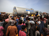 Displaced Palestinians are lining up to fill their containers with water in Deir Balah in the central Gaza Strip on April 25, 2024, amid ong...