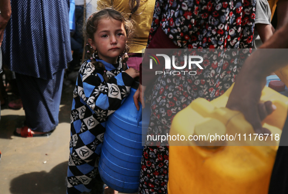 Displaced Palestinians are lining up to fill their containers with water in Deir Balah in the central Gaza Strip on April 25, 2024, amid ong...