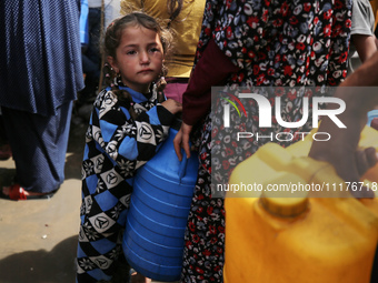 Displaced Palestinians are lining up to fill their containers with water in Deir Balah in the central Gaza Strip on April 25, 2024, amid ong...