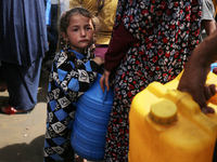 Displaced Palestinians are lining up to fill their containers with water in Deir Balah in the central Gaza Strip on April 25, 2024, amid ong...