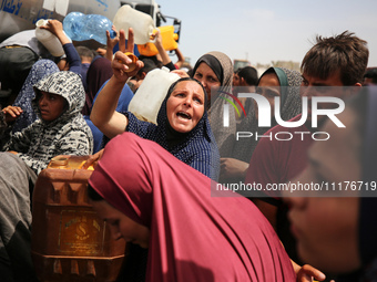 Displaced Palestinians are lining up to fill their containers with water in Deir Balah in the central Gaza Strip on April 25, 2024, amid ong...