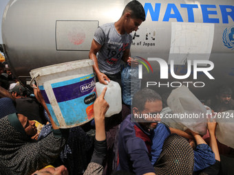 Displaced Palestinians are lining up to fill their containers with water in Deir Balah in the central Gaza Strip on April 25, 2024, amid ong...