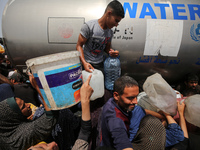 Displaced Palestinians are lining up to fill their containers with water in Deir Balah in the central Gaza Strip on April 25, 2024, amid ong...