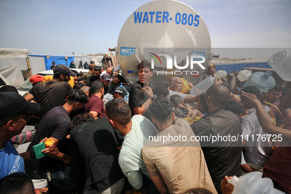 Displaced Palestinians are lining up to fill their containers with water in Deir Balah in the central Gaza Strip on April 25, 2024, amid ong...