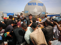 Displaced Palestinians are lining up to fill their containers with water in Deir Balah in the central Gaza Strip on April 25, 2024, amid ong...