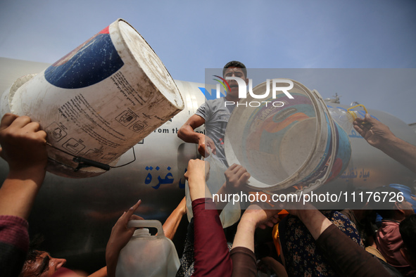 Displaced Palestinians are lining up to fill their containers with water in Deir Balah in the central Gaza Strip on April 25, 2024, amid ong...