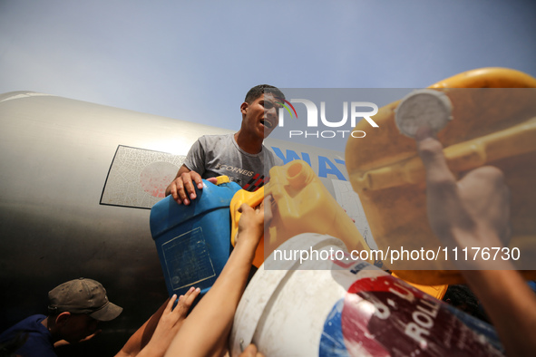 Displaced Palestinians are lining up to fill their containers with water in Deir Balah in the central Gaza Strip on April 25, 2024, amid ong...