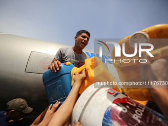 Displaced Palestinians are lining up to fill their containers with water in Deir Balah in the central Gaza Strip on April 25, 2024, amid ong...