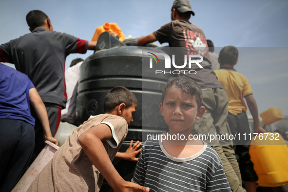 Displaced Palestinians are lining up to fill their containers with water in Deir Balah in the central Gaza Strip on April 25, 2024, amid ong...