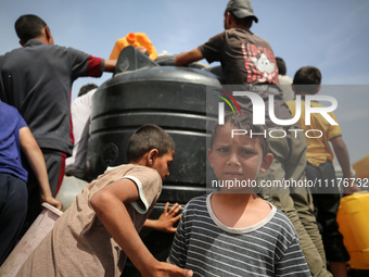 Displaced Palestinians are lining up to fill their containers with water in Deir Balah in the central Gaza Strip on April 25, 2024, amid ong...