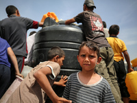 Displaced Palestinians are lining up to fill their containers with water in Deir Balah in the central Gaza Strip on April 25, 2024, amid ong...