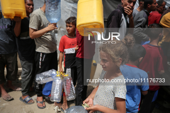 Displaced Palestinians are lining up to fill their containers with water in Deir Balah in the central Gaza Strip on April 25, 2024, amid ong...