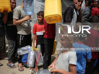 Displaced Palestinians are lining up to fill their containers with water in Deir Balah in the central Gaza Strip on April 25, 2024, amid ong...