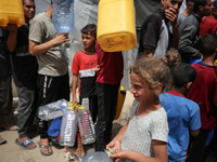 Displaced Palestinians are lining up to fill their containers with water in Deir Balah in the central Gaza Strip on April 25, 2024, amid ong...