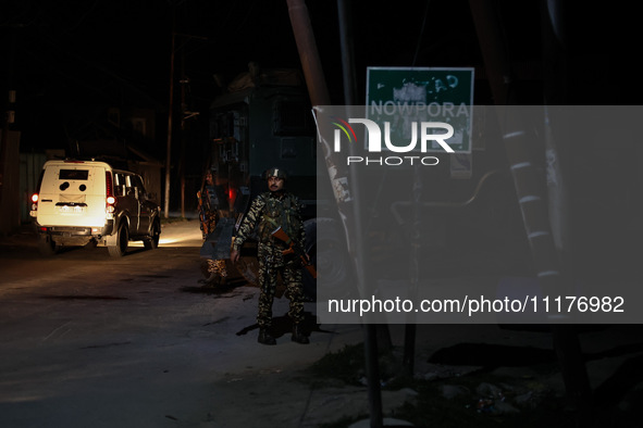 Security forces are standing near the encounter site where a confrontation between militants and Indian forces began in Nowpora Sopore, Jamm...