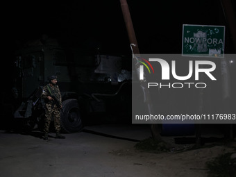 Security forces are standing near the encounter site where a confrontation between militants and Indian forces began in Nowpora Sopore, Jamm...