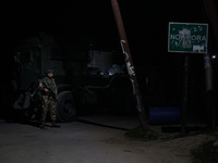 Security forces are standing near the encounter site where a confrontation between militants and Indian forces began in Nowpora Sopore, Jamm...