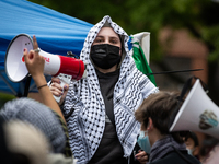 A demonstrator leads chants at an encampment for Palestine at George Washington University (GWU), Washington, DC, April 25, 2024.  Students...