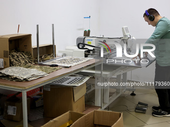 An employee is working in headphones at the Dzhavelina factory, which is manufacturing backpacks for the military in the Ivano-Frankivsk Reg...