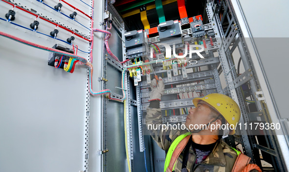 A construction worker is installing electrical equipment at the incineration workshop of the Zhangye Hazardous Waste (solid waste) Disposal...