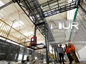 Technicians are checking the installed bridge at the biochemical center of the construction project for the Hazardous Waste (solid waste) Di...