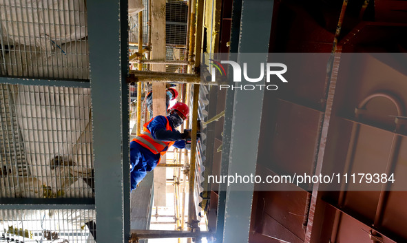 Construction workers are installing equipment at the biochemical center of the Zhangye Hazardous Waste (solid waste) disposal and resource u...