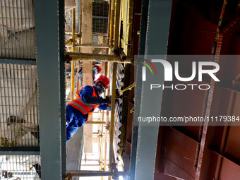 Construction workers are installing equipment at the biochemical center of the Zhangye Hazardous Waste (solid waste) disposal and resource u...