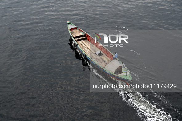 People are crossing the pitch-black polluted waters of the Buriganga River on a boat in Dhaka, Bangladesh, on April 26, 2024. Bangladesh has...