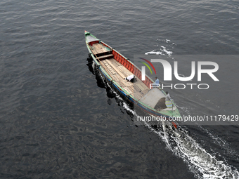 People are crossing the pitch-black polluted waters of the Buriganga River on a boat in Dhaka, Bangladesh, on April 26, 2024. Bangladesh has...