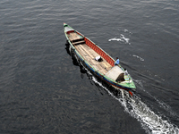 People are crossing the pitch-black polluted waters of the Buriganga River on a boat in Dhaka, Bangladesh, on April 26, 2024. Bangladesh has...