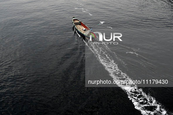 People are crossing the pitch-black polluted waters of the Buriganga River on a boat in Dhaka, Bangladesh, on April 26, 2024. Bangladesh has...