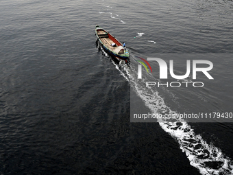 People are crossing the pitch-black polluted waters of the Buriganga River on a boat in Dhaka, Bangladesh, on April 26, 2024. Bangladesh has...