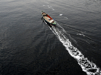 People are crossing the pitch-black polluted waters of the Buriganga River on a boat in Dhaka, Bangladesh, on April 26, 2024. Bangladesh has...