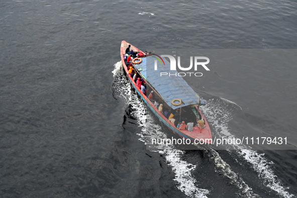 People are crossing the pitch-black polluted waters of the Buriganga River on a boat in Dhaka, Bangladesh, on April 26, 2024. Bangladesh has...