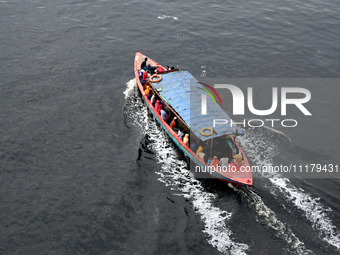 People are crossing the pitch-black polluted waters of the Buriganga River on a boat in Dhaka, Bangladesh, on April 26, 2024. Bangladesh has...