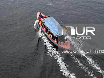 People are crossing the pitch-black polluted waters of the Buriganga River on a boat in Dhaka, Bangladesh, on April 26, 2024. Bangladesh has...