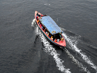 People are crossing the pitch-black polluted waters of the Buriganga River on a boat in Dhaka, Bangladesh, on April 26, 2024. Bangladesh has...