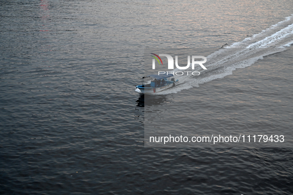 People are crossing the pitch-black polluted waters of the Buriganga River on a boat in Dhaka, Bangladesh, on April 26, 2024. Bangladesh has...