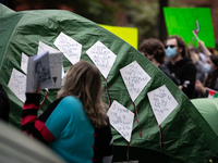 Kite-shaped signs containing the lines of Refaat Alareer's poem, "If I Must Die," written before he was killed by an Israeli airstrike, ador...