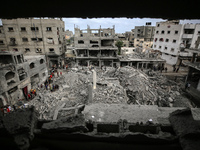 Palestinians are checking the damage in a house that was destroyed by an overnight Israeli bombardment in Nuseirat camp in the central Gaza...