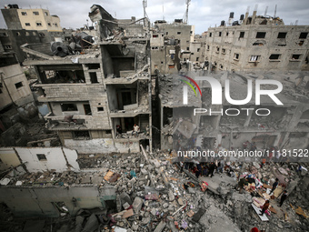 Palestinians are checking the damage in a house that was destroyed by an overnight Israeli bombardment in Nuseirat camp in the central Gaza...