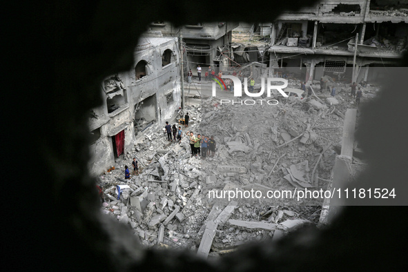 Palestinians are checking the damage in a house that was destroyed by an overnight Israeli bombardment in Nuseirat camp in the central Gaza...