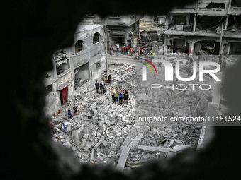 Palestinians are checking the damage in a house that was destroyed by an overnight Israeli bombardment in Nuseirat camp in the central Gaza...