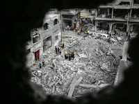 Palestinians are checking the damage in a house that was destroyed by an overnight Israeli bombardment in Nuseirat camp in the central Gaza...