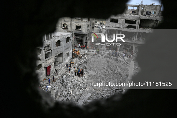 Palestinians are checking the damage in a house that was destroyed by an overnight Israeli bombardment in Nuseirat camp in the central Gaza...