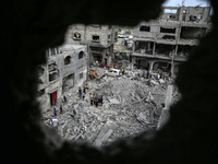 Palestinians are checking the damage in a house that was destroyed by an overnight Israeli bombardment in Nuseirat camp in the central Gaza...