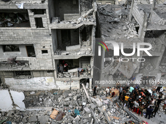 Palestinians are checking the damage in a house that was destroyed by an overnight Israeli bombardment in Nuseirat camp in the central Gaza...