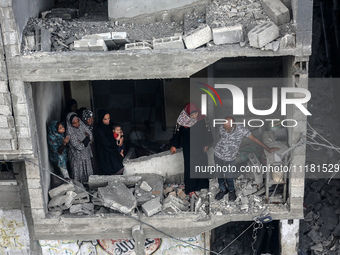 Palestinians are checking the damage in a house that was destroyed by an overnight Israeli bombardment in Nuseirat camp in the central Gaza...