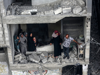 Palestinians are checking the damage in a house that was destroyed by an overnight Israeli bombardment in Nuseirat camp in the central Gaza...