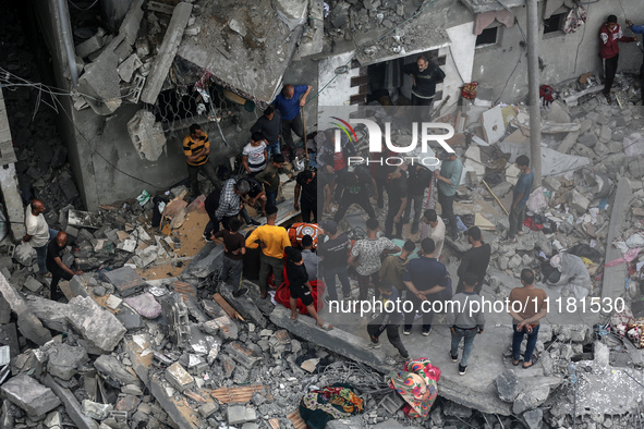 Palestinians are checking the damage in a house that was destroyed by an overnight Israeli bombardment in Nuseirat camp in the central Gaza...